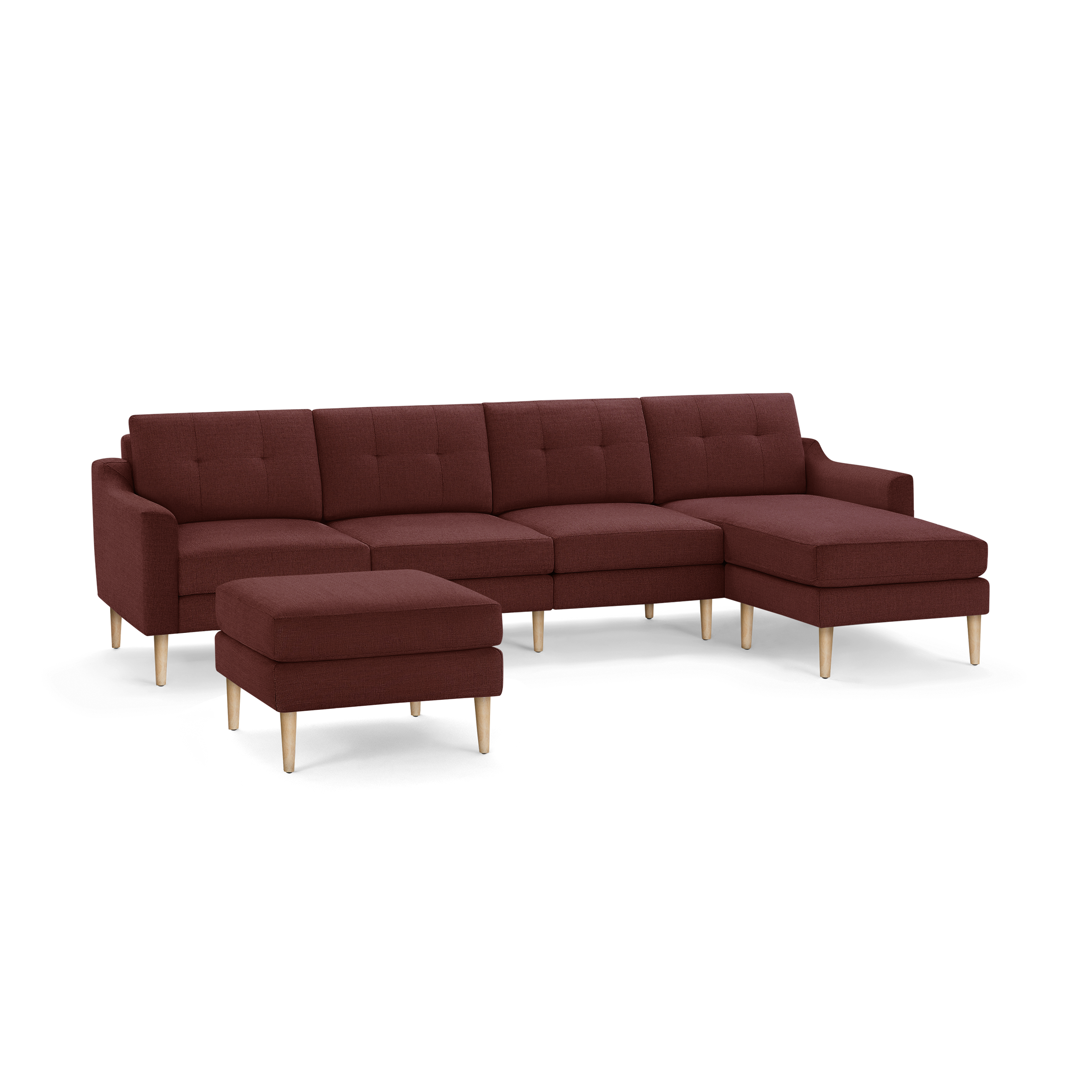 Modern deep red sectional sofa with tufted cushions, wooden legs, and matching ottoman on black background.