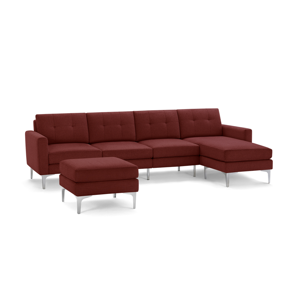 Modern sectional sofa in deep red fabric with tufted back cushions, metal legs, and matching ottoman.