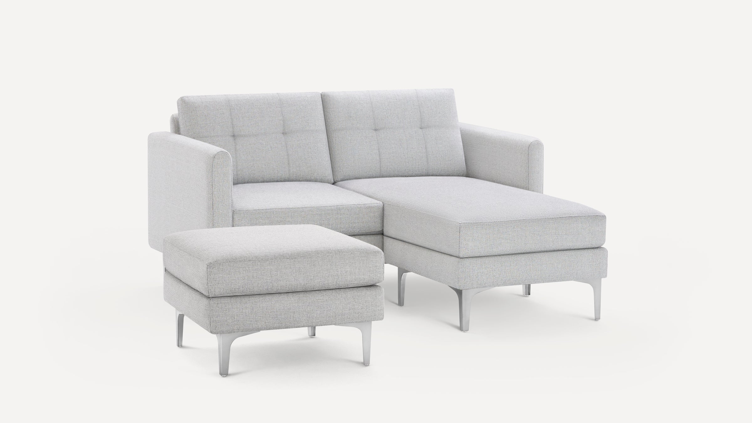 Light gray modern sectional sofa with tufted back cushions and matching ottoman, supported by sleek metal legs.