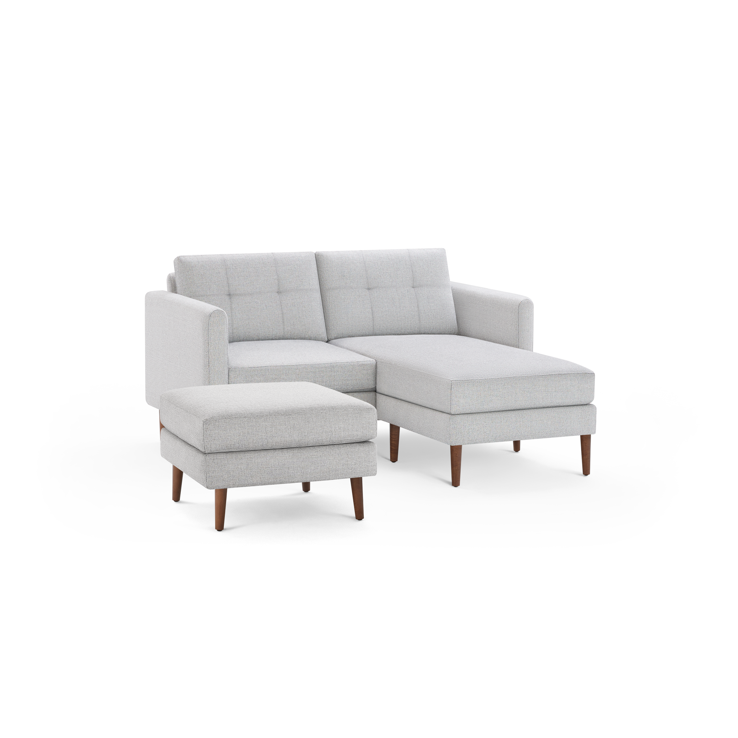 Light gray modern sectional sofa with tufted cushions and wooden legs, accompanied by a matching ottoman.