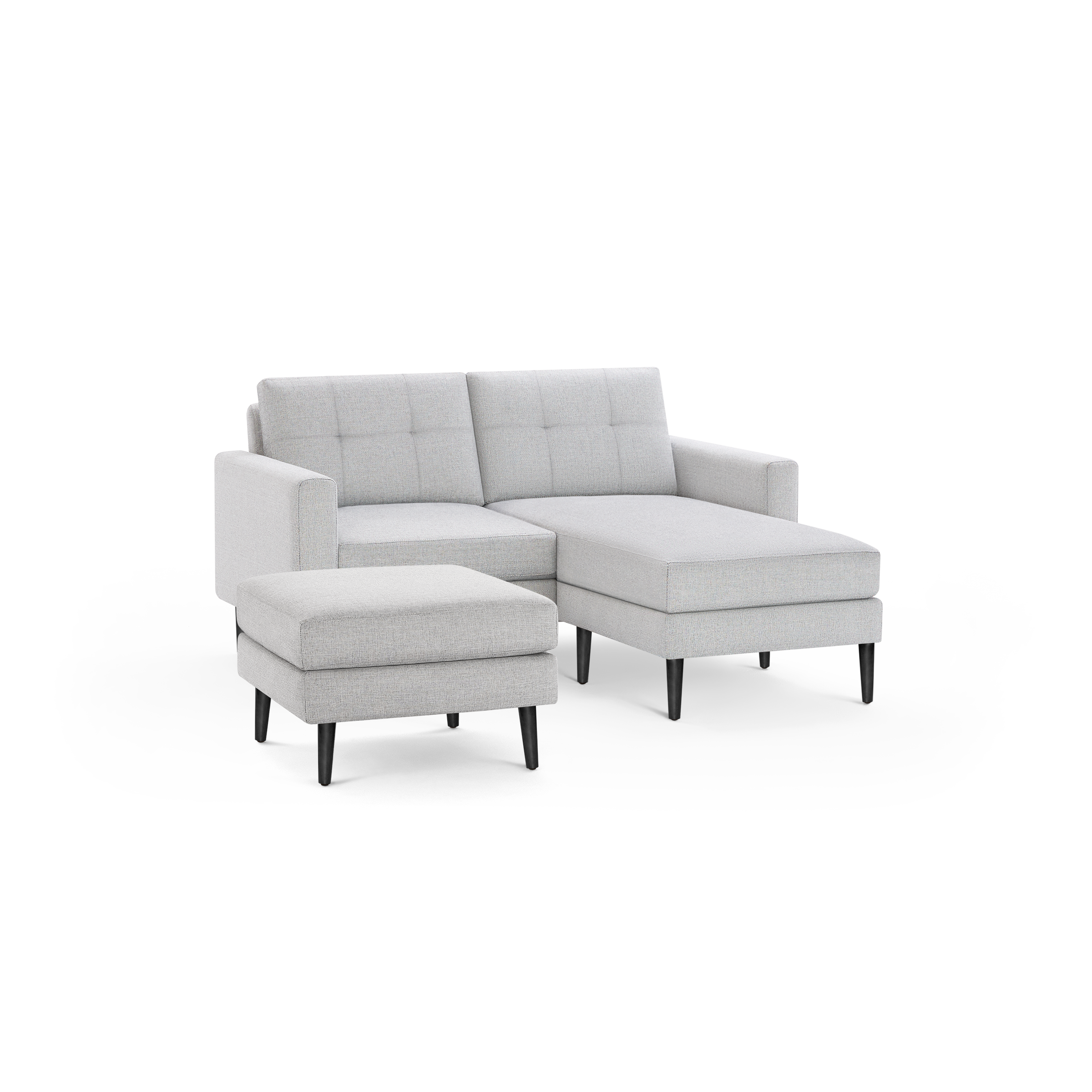 Light gray upholstered sectional sofa with tufted back cushions, wooden legs, and matching ottoman on black background.