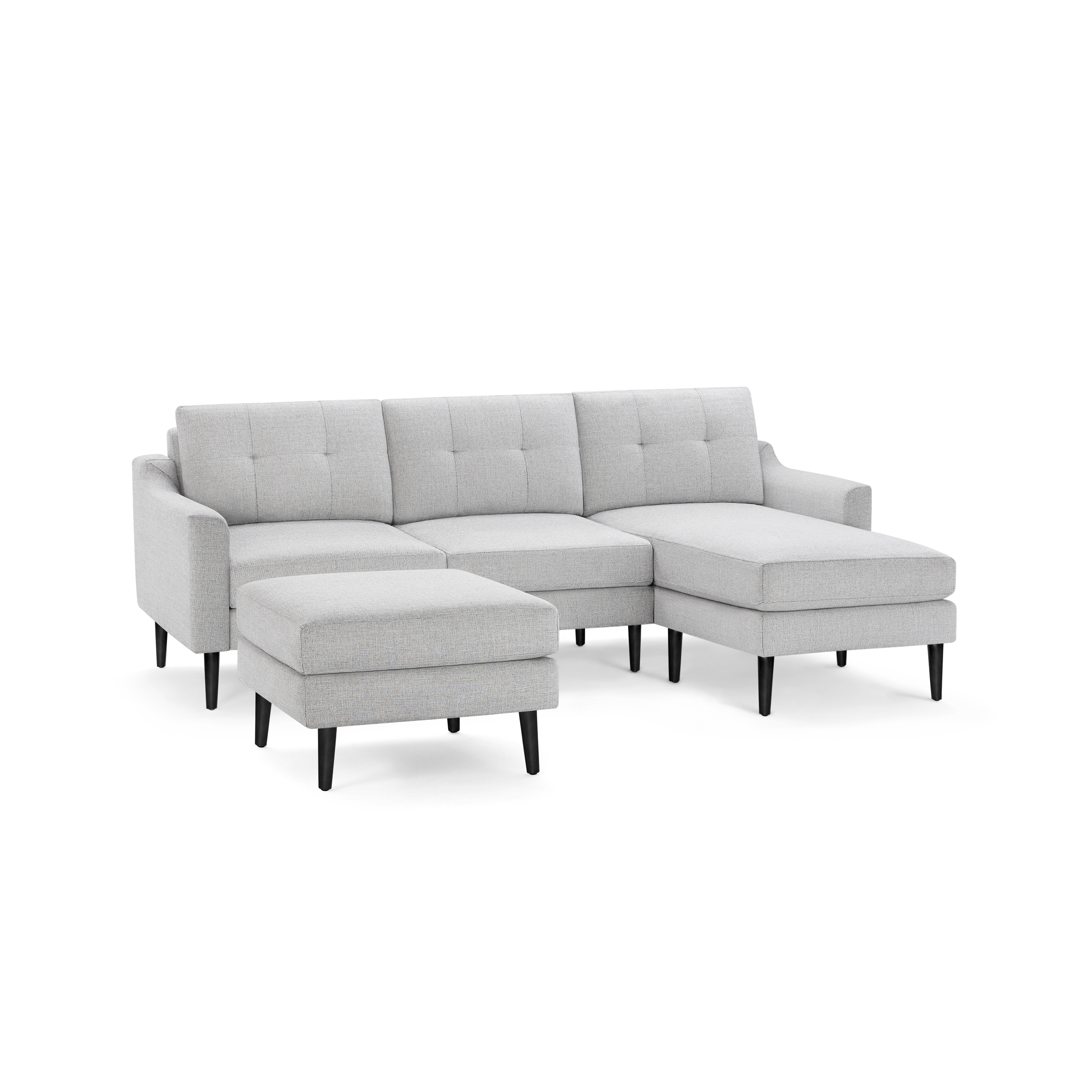 Light gray fabric sectional sofa with tufted back cushions, left armrest, chaise lounge on right, and matching ottoman, supported by black tapered legs.