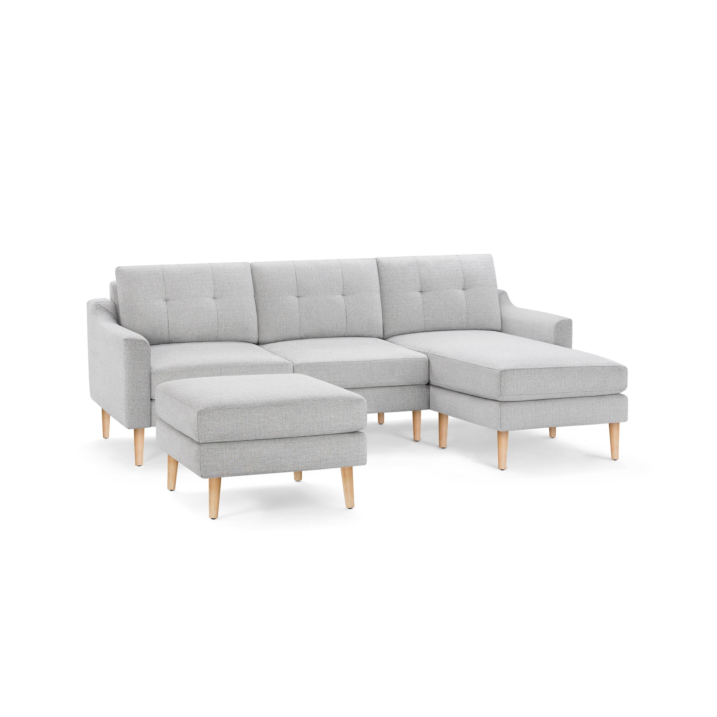 Light gray modern sectional sofa with tufted cushions, wooden legs, and matching ottoman, featuring a right-side chaise lounge.