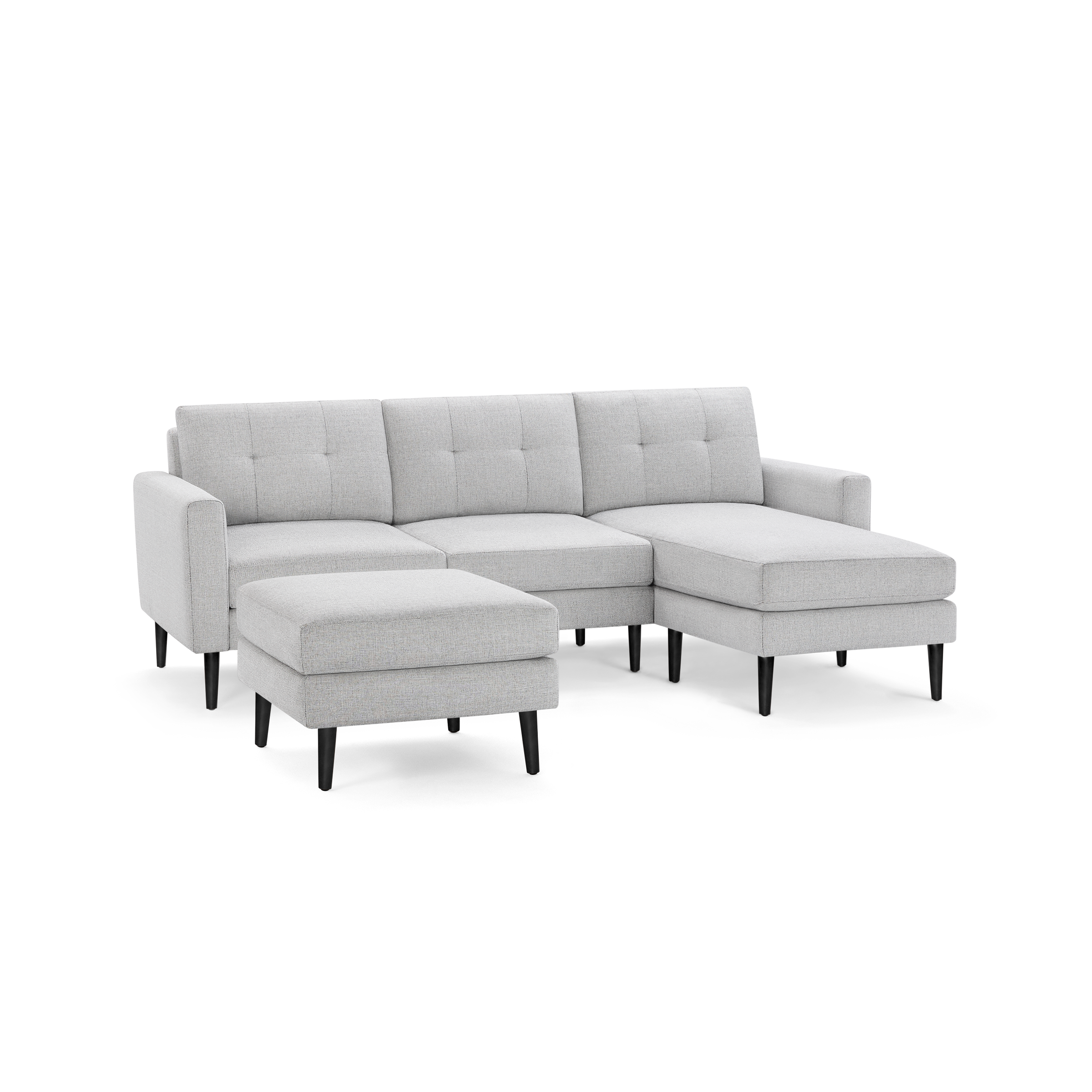 Light gray fabric sectional sofa with tufted back cushions, black tapered legs, and matching ottoman.
