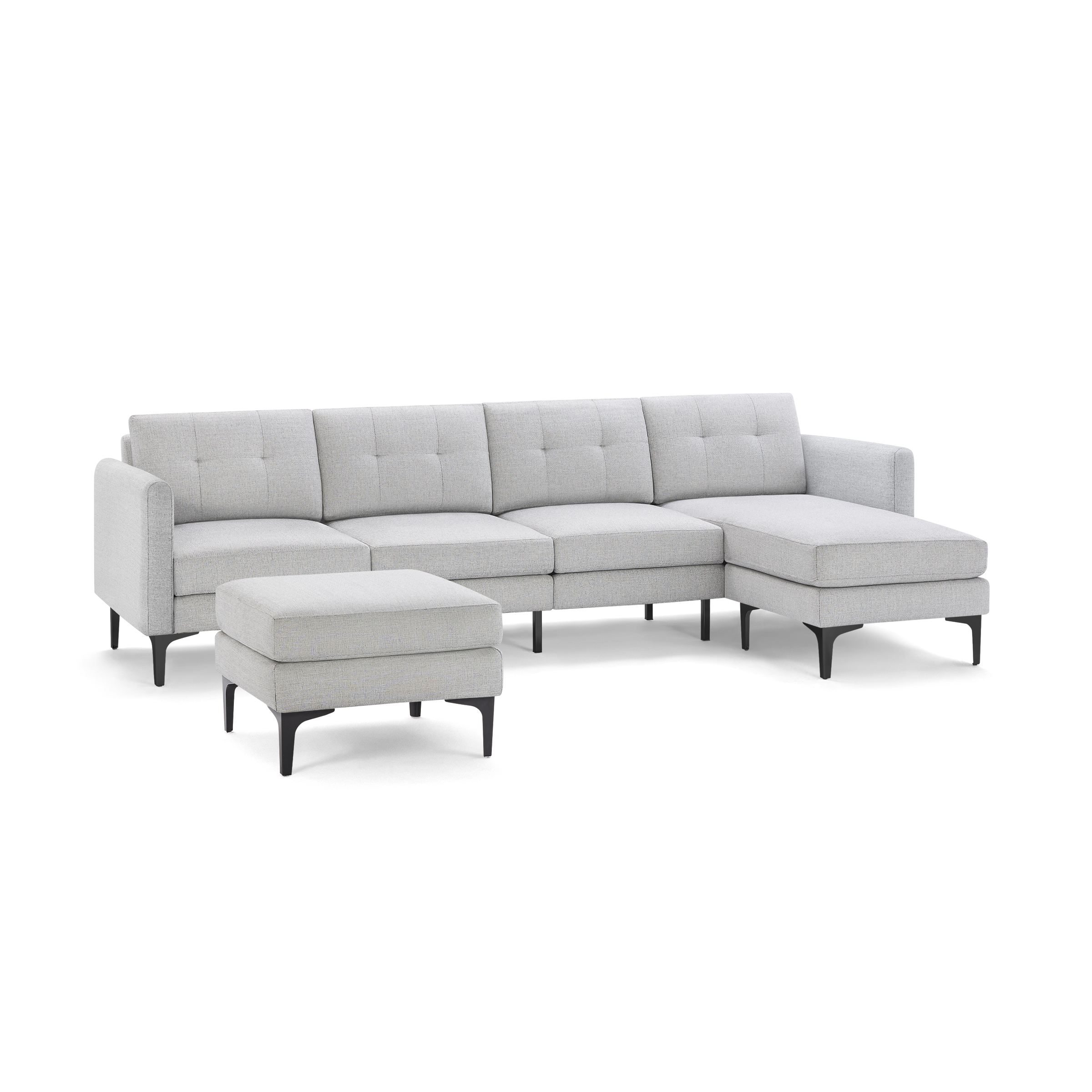 Light gray L-shaped sectional sofa with tufted cushions and matching ottoman, supported by black tapered legs.