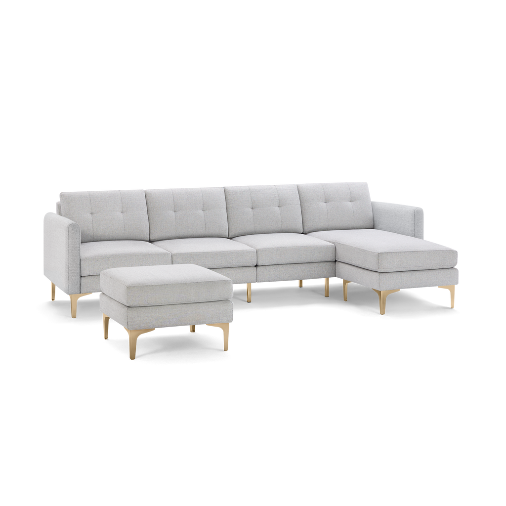 Light gray modern sectional sofa with tufted back cushions, right chaise, and matching ottoman standing on gold metal legs.