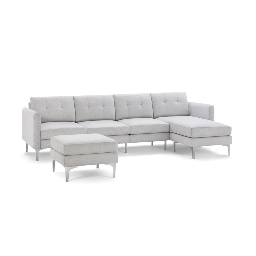 Light gray fabric sectional sofa with tufted cushions, metal legs, and matching ottoman isolated on black background.