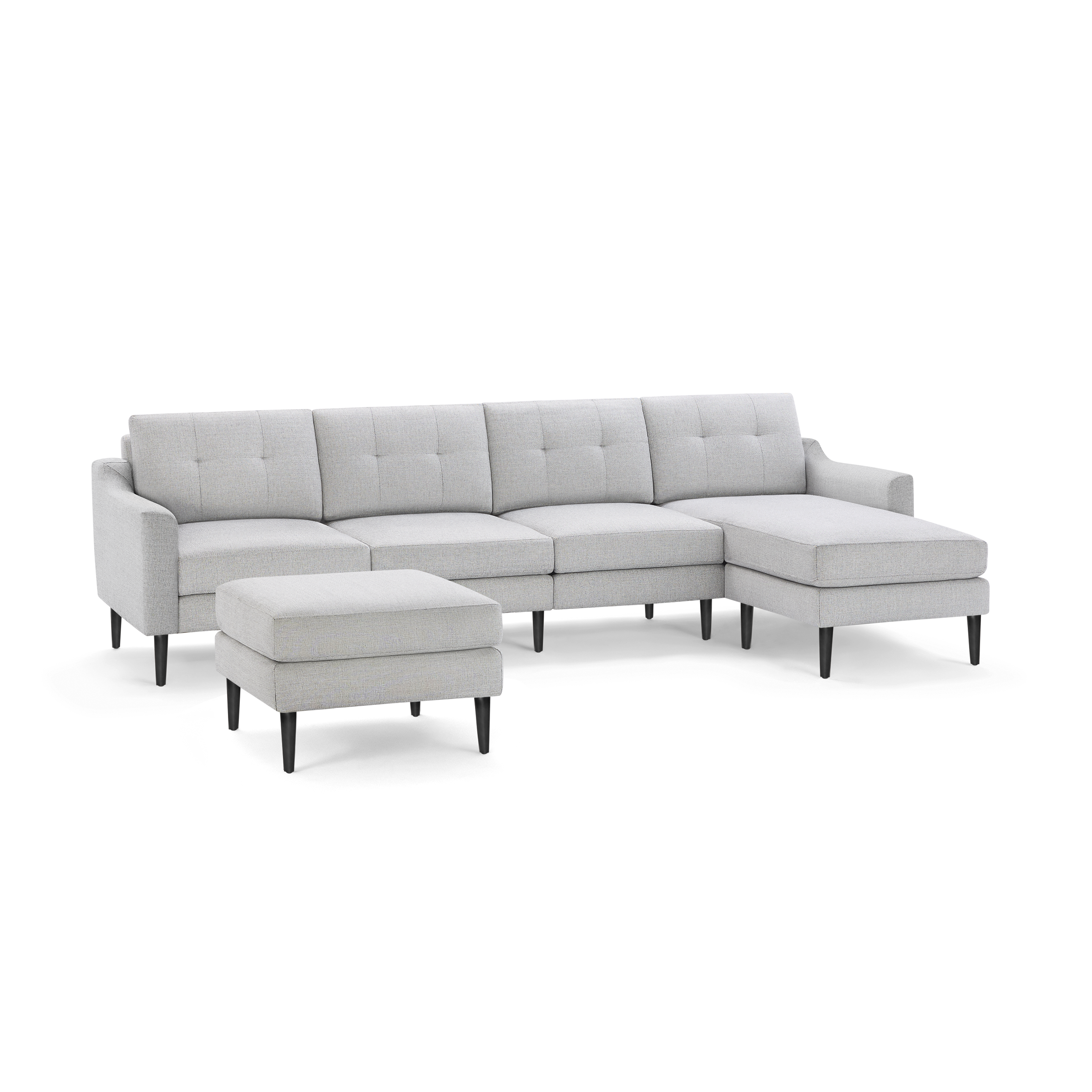 Light gray modern sectional sofa with tufted cushions, black wooden legs, and a matching ottoman isolated on black background.