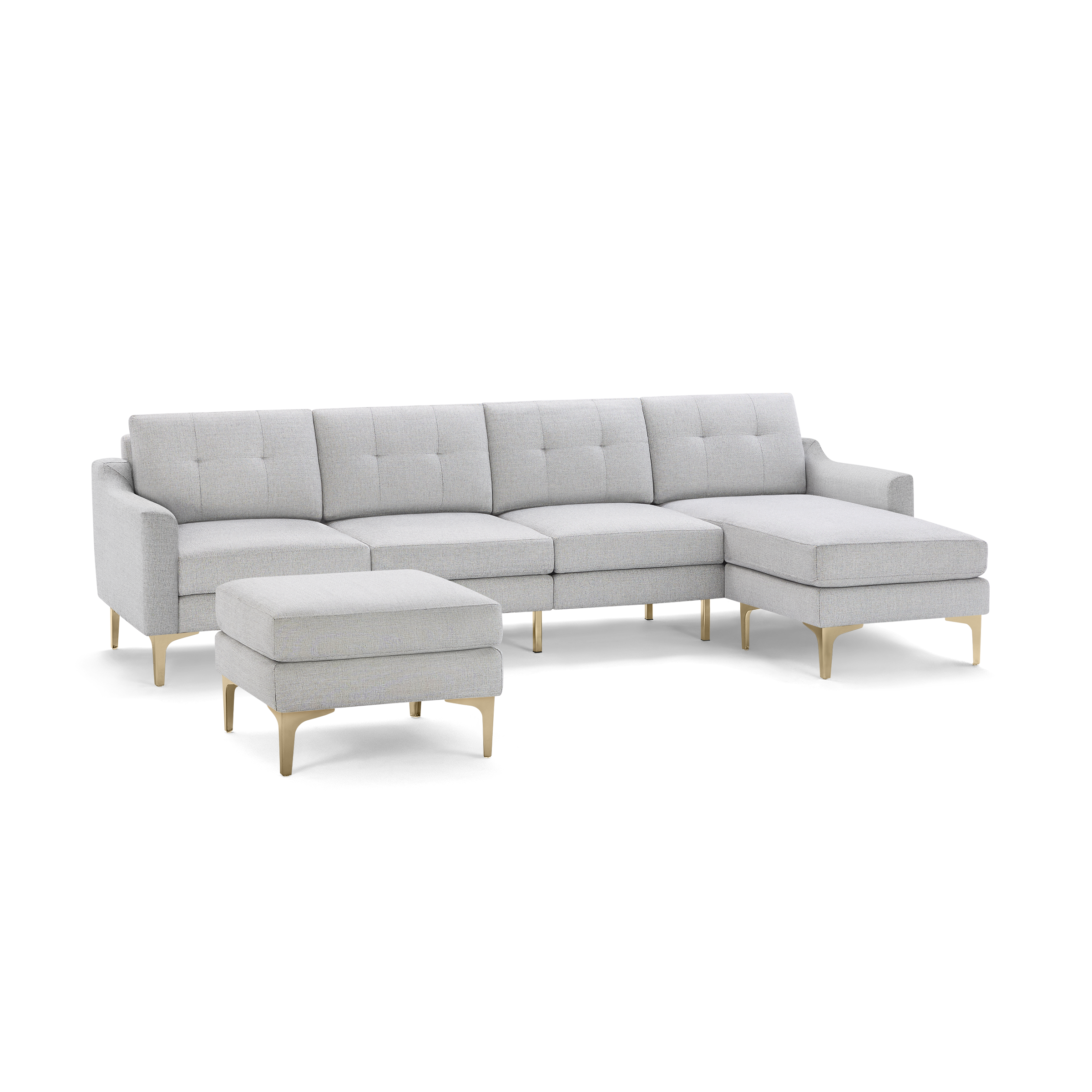 Light gray sectional sofa with tufted cushions, wooden legs, and a matching ottoman, modern and spacious design.