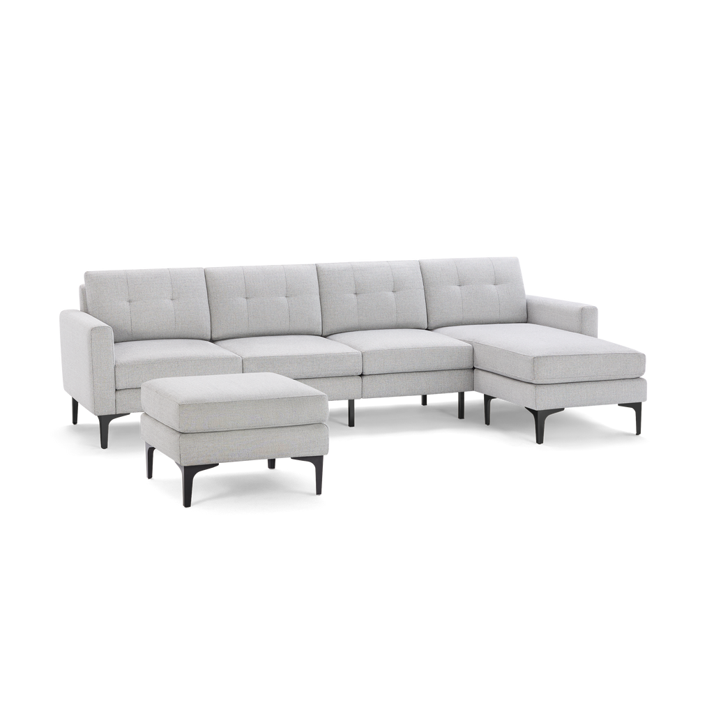 Light gray fabric sectional sofa with tufted back cushions, chaise lounge on right, and matching ottoman, all supported by black legs.