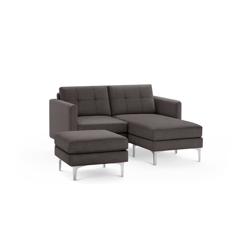 Modern dark gray fabric sectional sofa with clean lines, tufted back cushions, metal legs, and a matching ottoman.