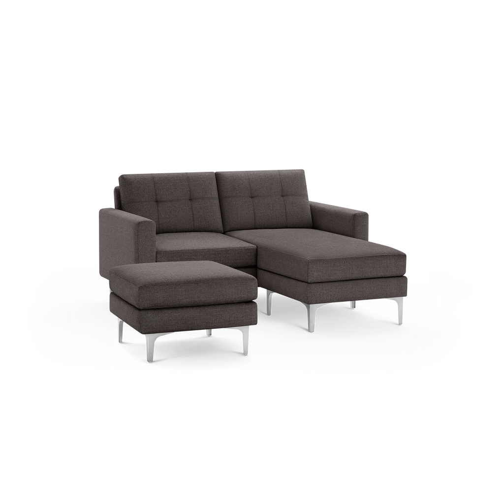 Modern dark gray fabric sectional sofa with tufted back cushions and metal legs, including a matching ottoman.