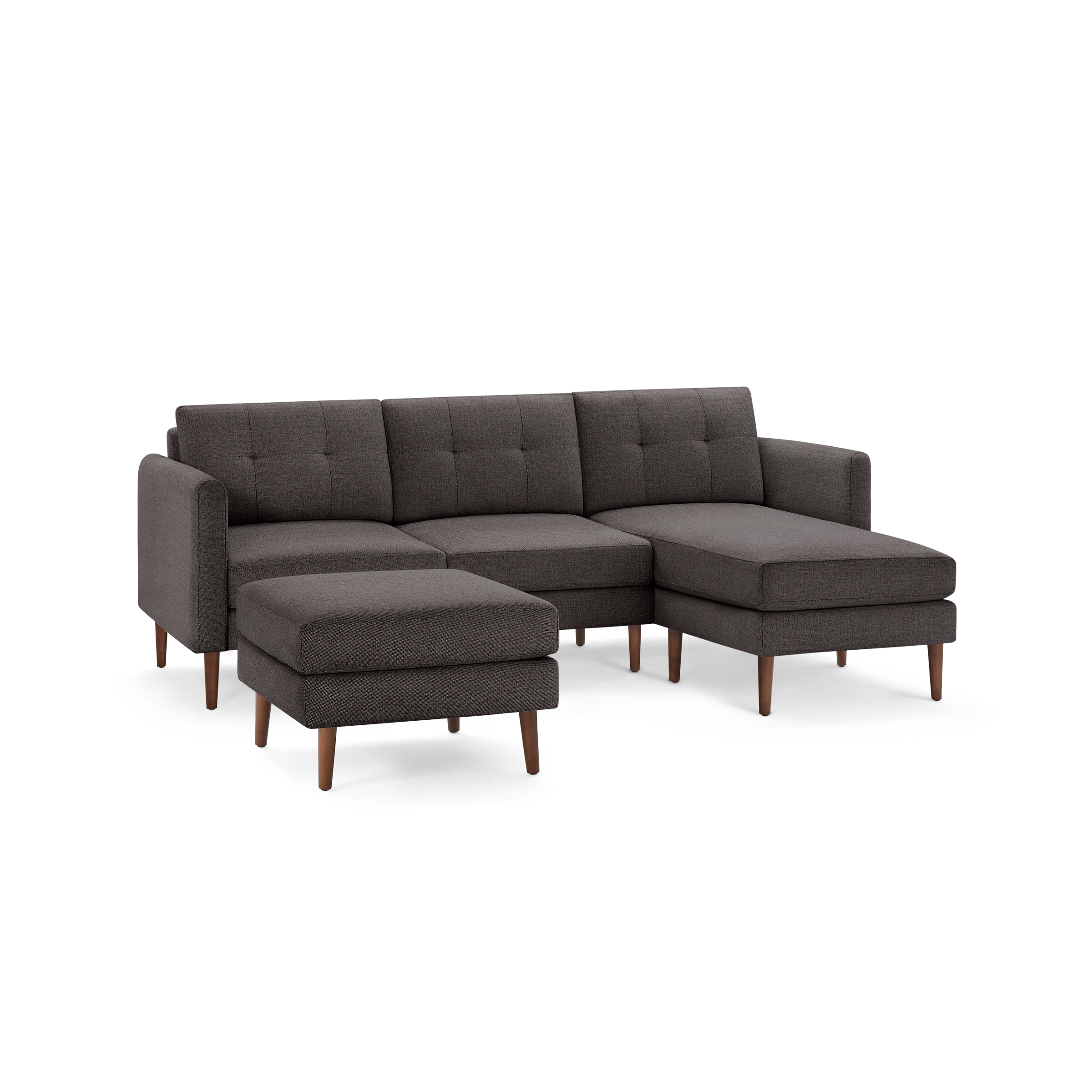 Dark gray fabric sectional sofa with tufted back cushions, wooden legs, and a matching ottoman, modern design.
