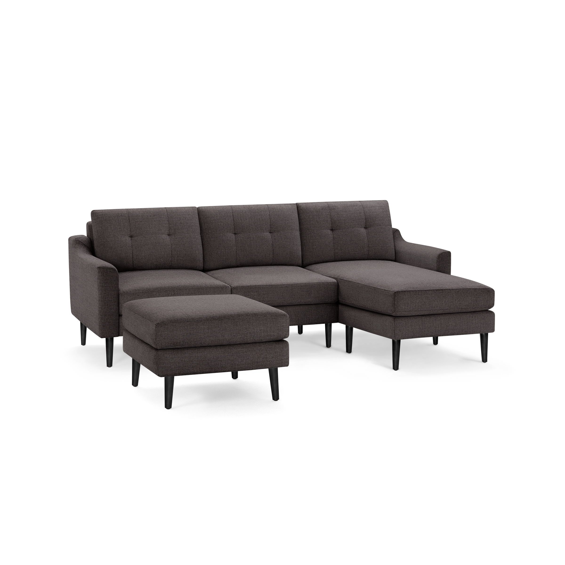 Dark gray sectional sofa with tufted back cushions, angled armrests, black tapered legs, and matching ottoman.