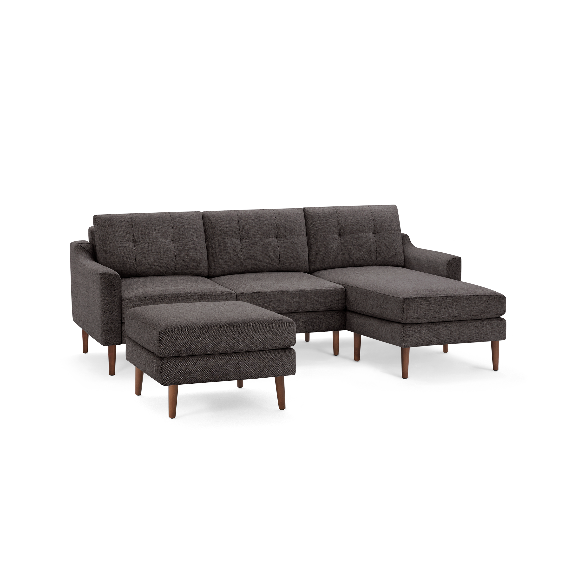 Dark gray fabric sectional sofa with tufted back cushions and wooden legs, including a matching ottoman.