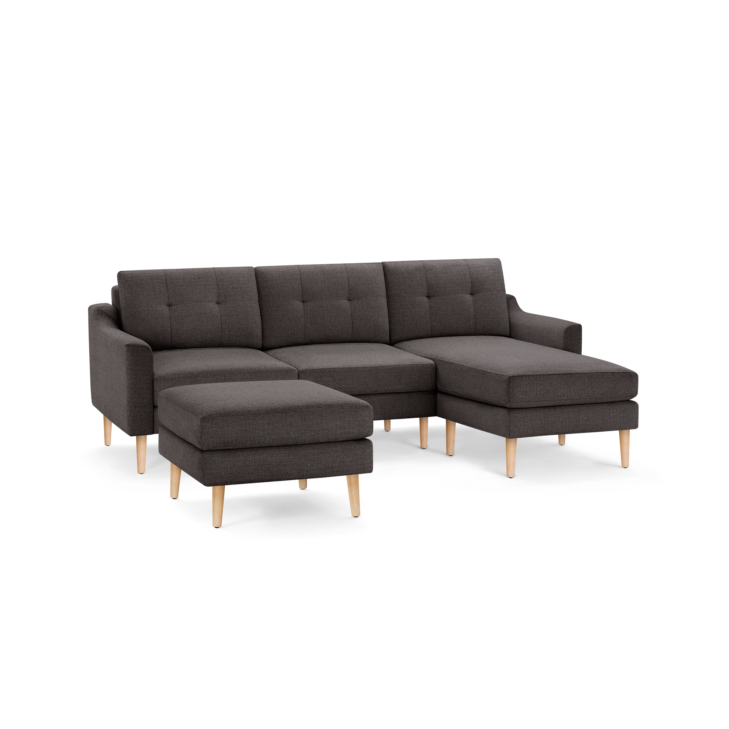Dark gray fabric sectional sofa with tufted cushions, wooden legs, and a matching ottoman.