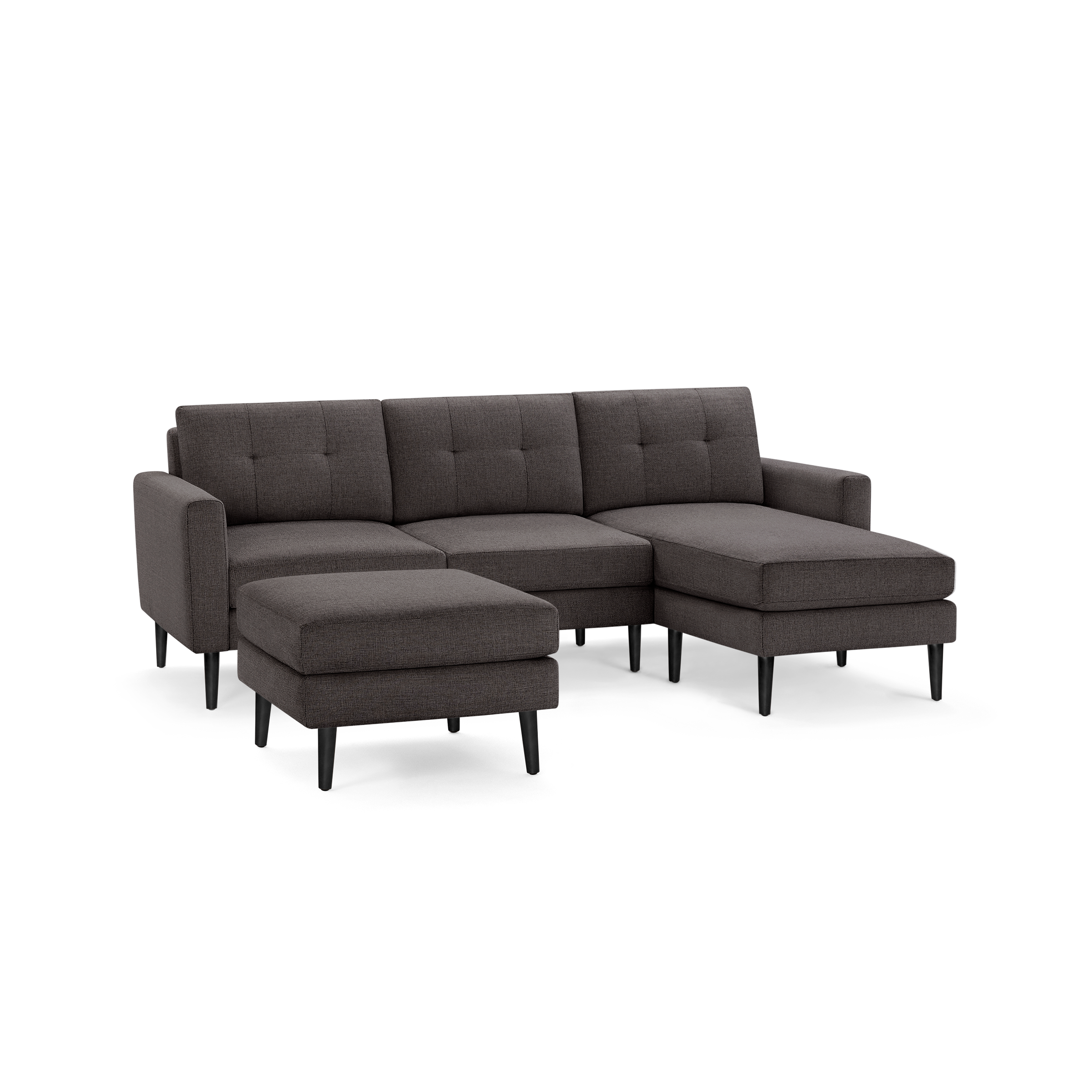Dark gray fabric sectional sofa with tufted back, chaise lounge on the right, and matching ottoman on black legs.