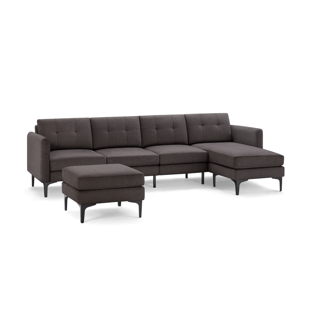 Dark gray fabric sectional sofa with chaise lounge and matching ottoman, featuring tufted back cushions and modern black metal legs.