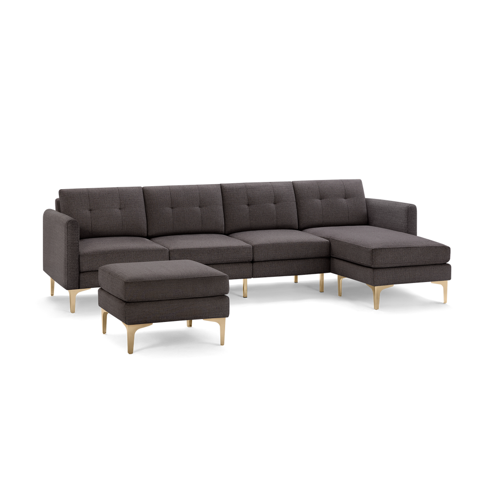 Dark gray modern sectional sofa with tufted cushions and matching ottoman, featuring sleek gold-tone metal legs.