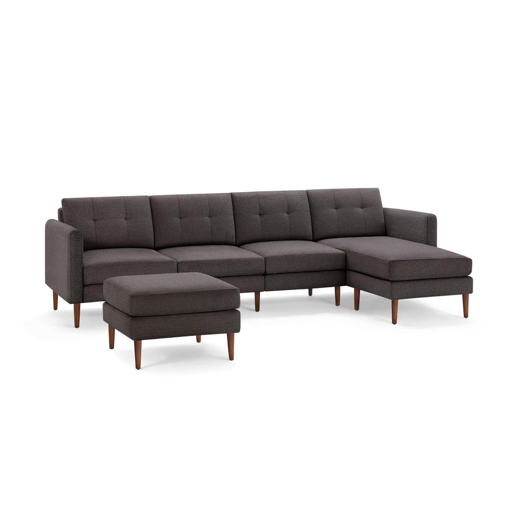 Dark gray mid-century modern sectional sofa with tufted cushions and wooden legs, includes matching ottoman.
