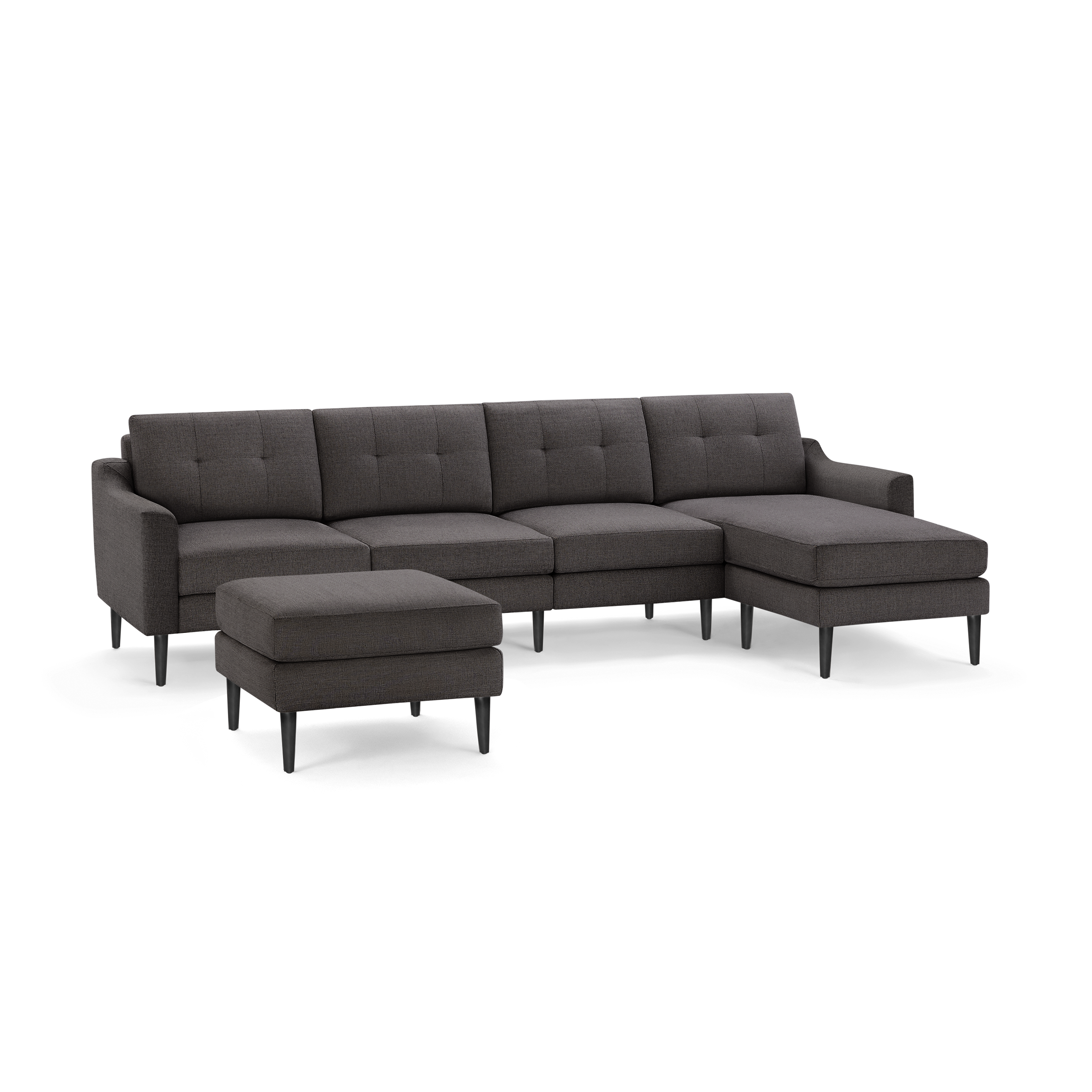 Dark gray fabric sectional sofa with tufted back cushions, slim black legs, and a matching ottoman.