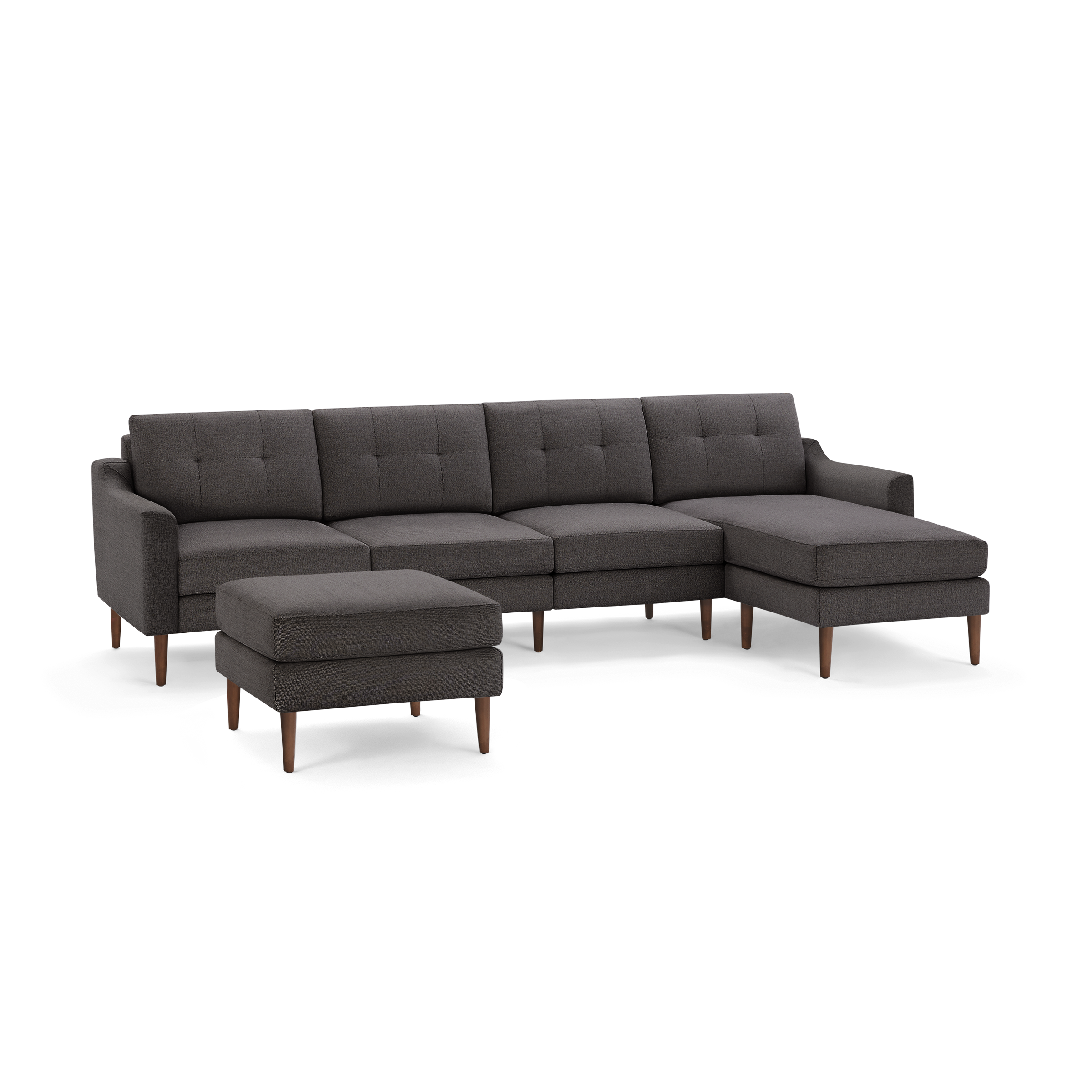Dark gray mid-century modern sectional sofa with tufted cushions, wooden tapered legs, and matching ottoman.