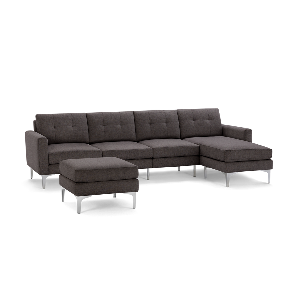 Modern dark gray sectional sofa with tufted cushions, metal legs, and matching ottoman.
