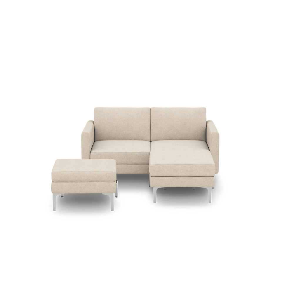 Beige fabric modern sectional sofa with chaise lounge and matching ottoman, featuring slim metal legs.