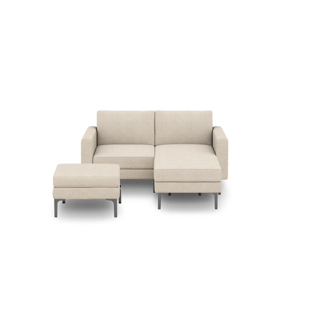 Modern beige fabric loveseat sofa with a matching ottoman, raised on black metal legs, minimalist design.