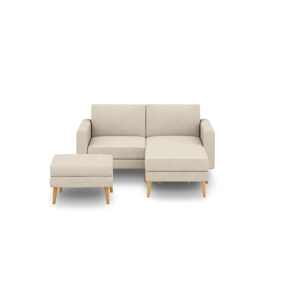 Beige fabric sectional sofa with chaise lounge and matching ottoman, featuring wooden legs and modern clean lines.