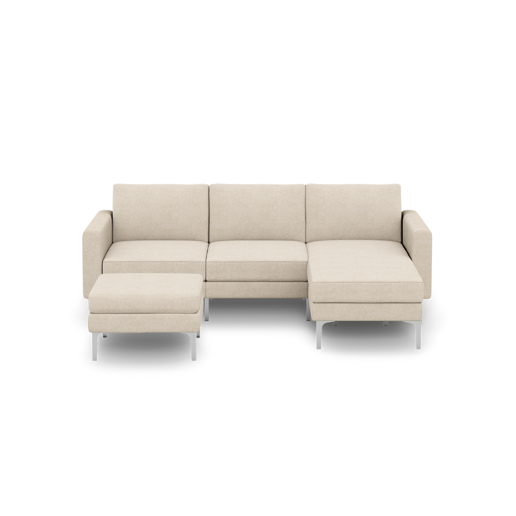 Beige modern sectional sofa with metal legs, including a three-seat section, chaise lounge on right, and matching ottoman.