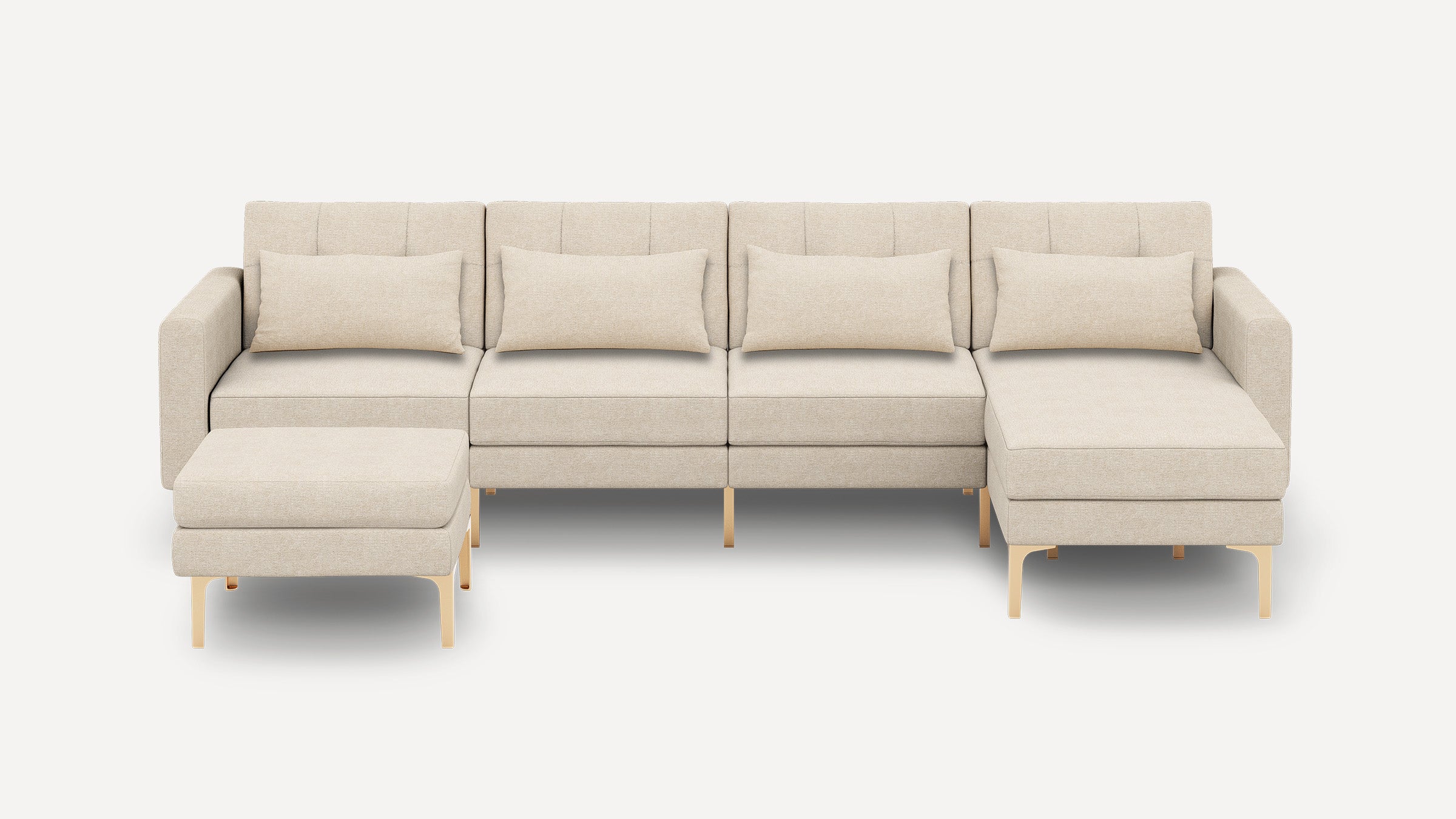Modern beige sectional sofa with four cushions, metal legs, and a matching ottoman on a plain white background.