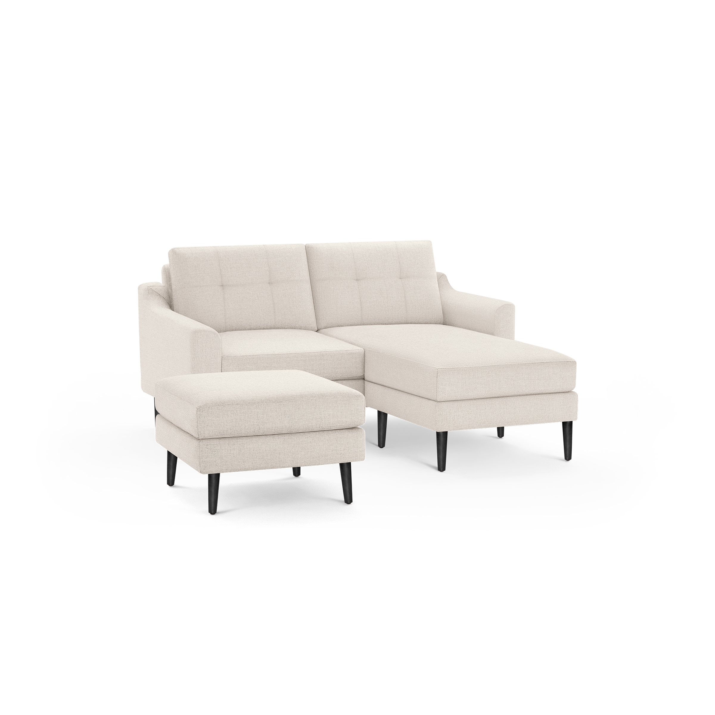 Light beige fabric sectional sofa with tufted back cushions, black tapered wooden legs, and a matching ottoman.