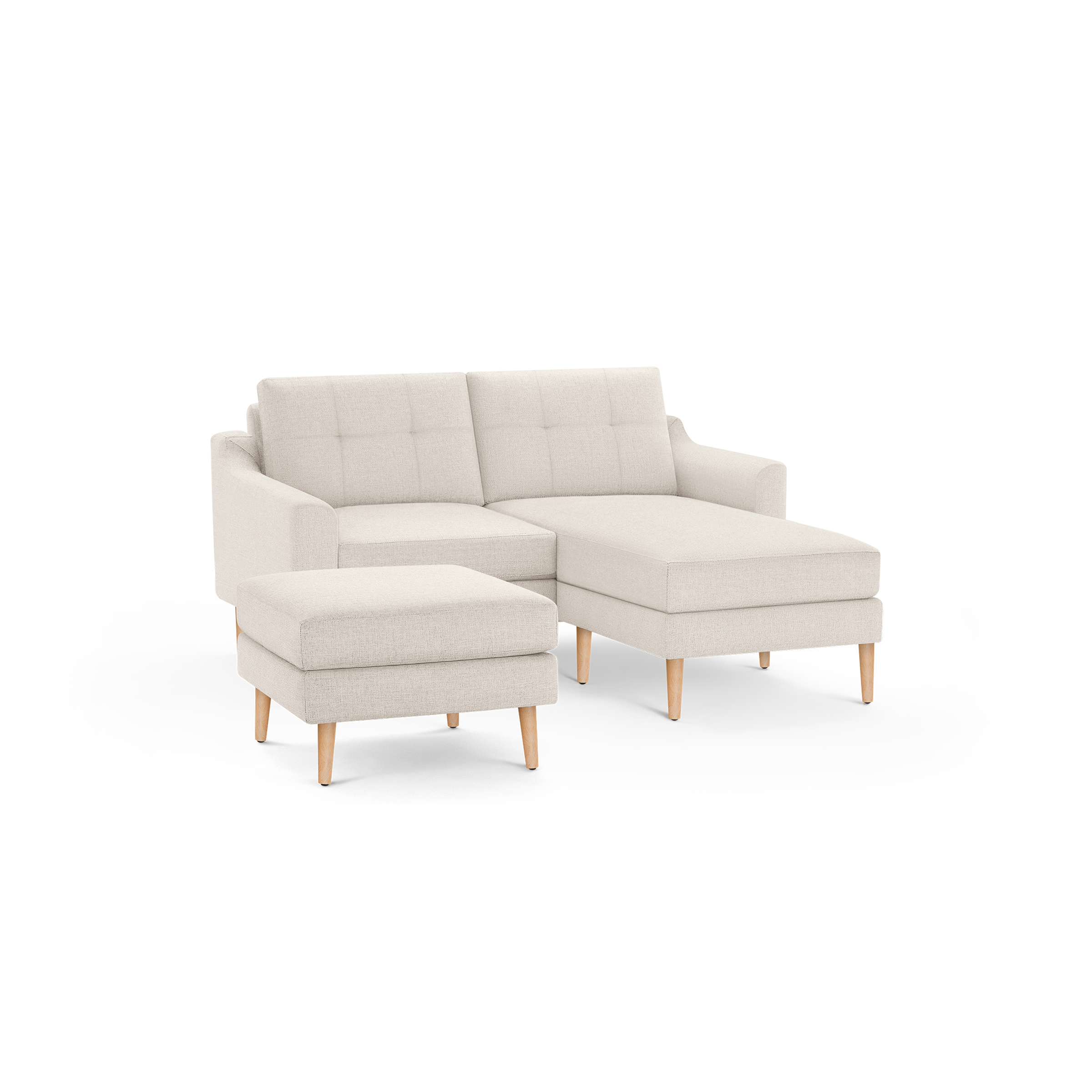 Light beige fabric sectional sofa with tufted backrests and matching ottoman, supported by wooden legs.