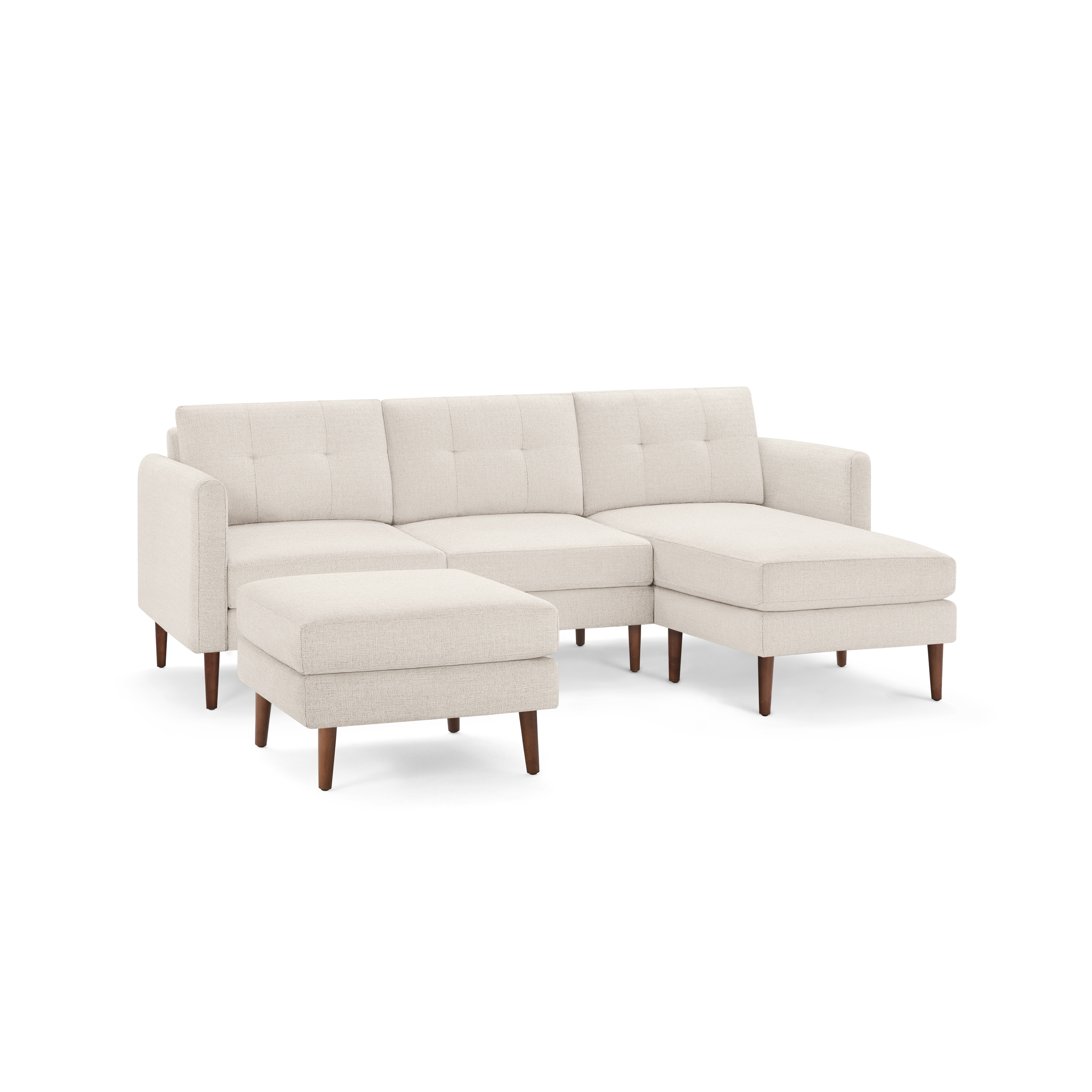 Cream-colored modern sectional sofa with tufted cushions, wooden legs, and a matching ottoman, L-shaped design.