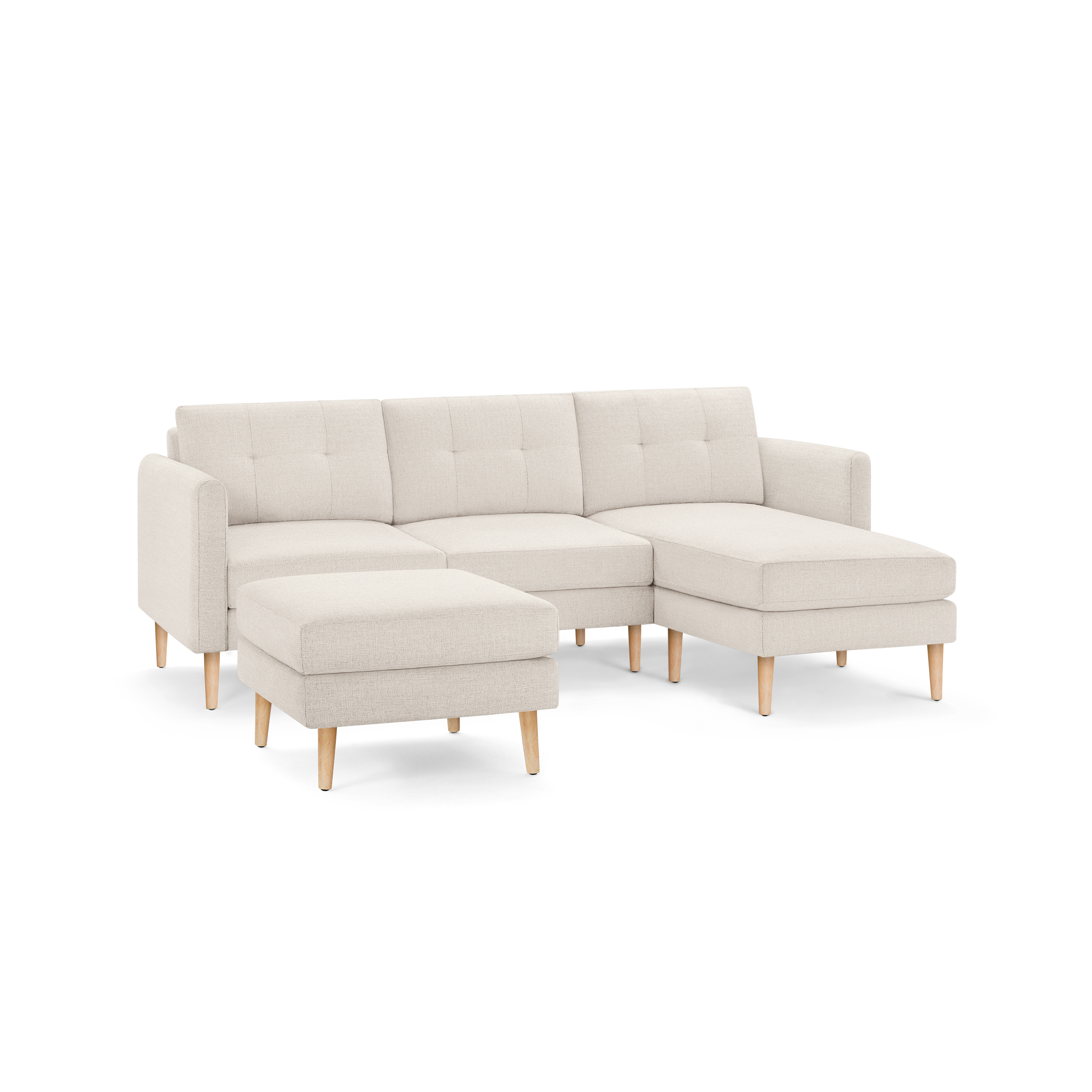 Light beige modern sectional sofa with tufted back cushions, wooden legs, and separate ottoman against transparent background.