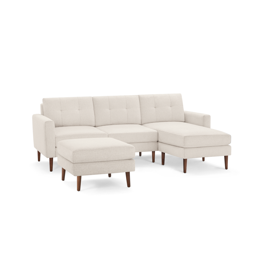 Beige modern sectional sofa with tufted back cushions, wooden legs, and matching ottoman, offering ample seating and comfort.