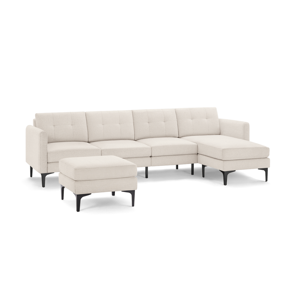 Beige fabric sectional sofa with tufted back cushions, black legs, and matching ottoman, featuring a chaise lounge on the right side.