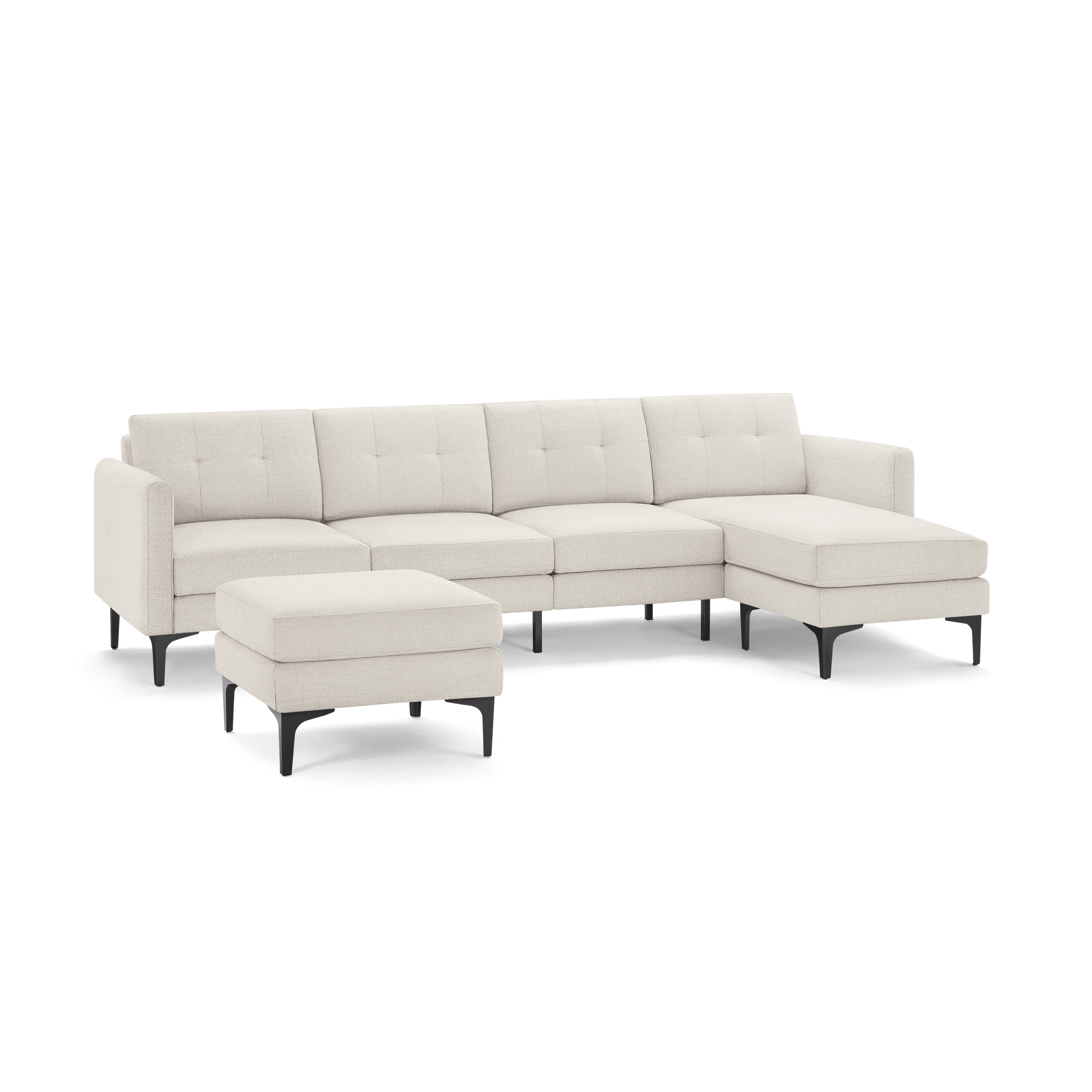 Beige fabric sectional sofa with tufted back cushions, black legs, and matching ottoman, featuring a chaise lounge on the right side.
