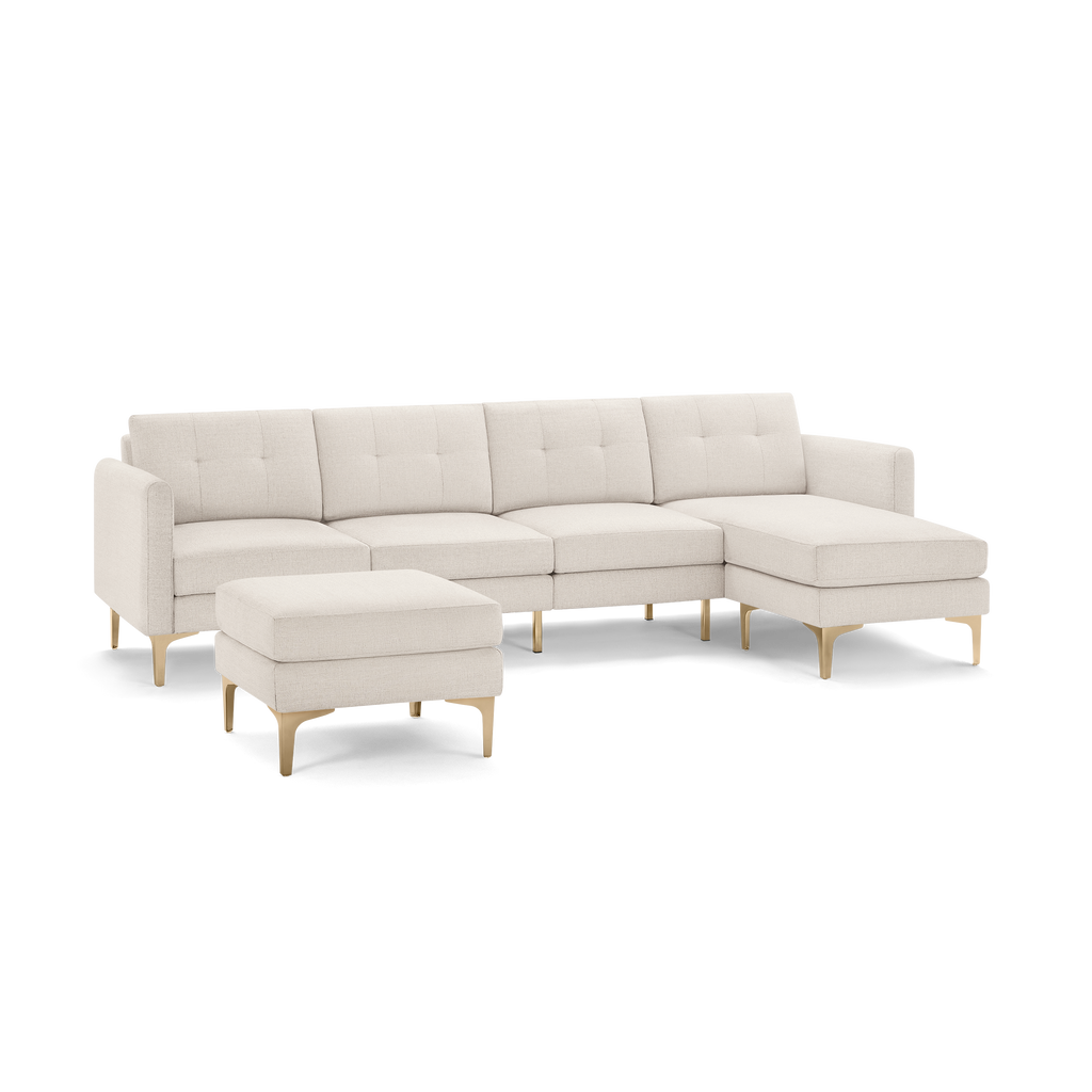 Modern beige sectional sofa with chaise lounge and matching ottoman, featuring tufted cushions and gold metal legs.