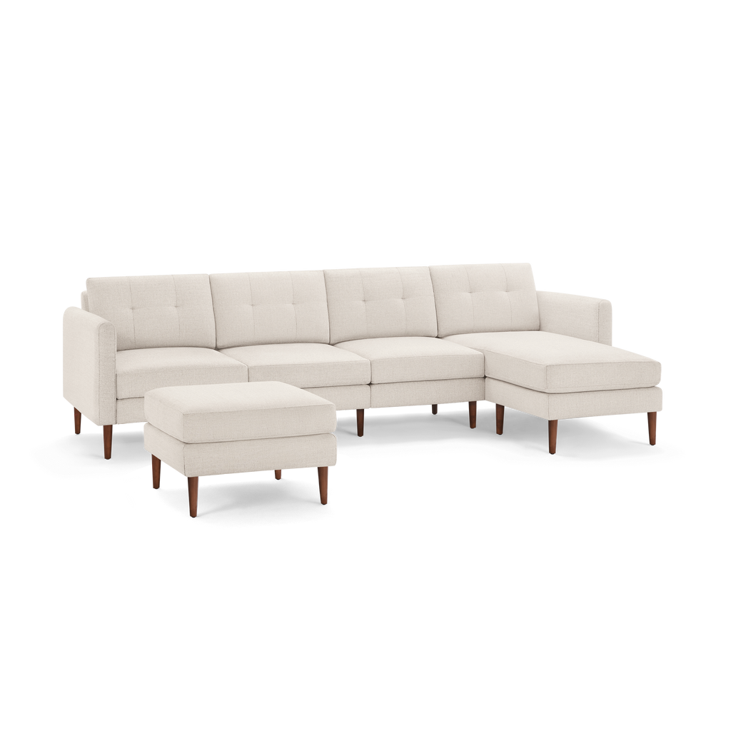 Beige sectional sofa with tufted cushions, wooden legs, and a matching ottoman, featuring a modern and minimalist design.