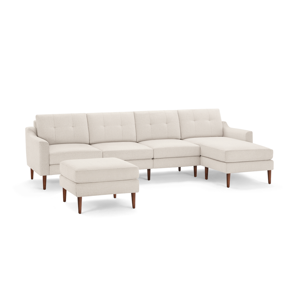 Beige fabric sectional sofa with tufted back cushions, wooden legs, and a matching ottoman, featuring a right-side chaise.