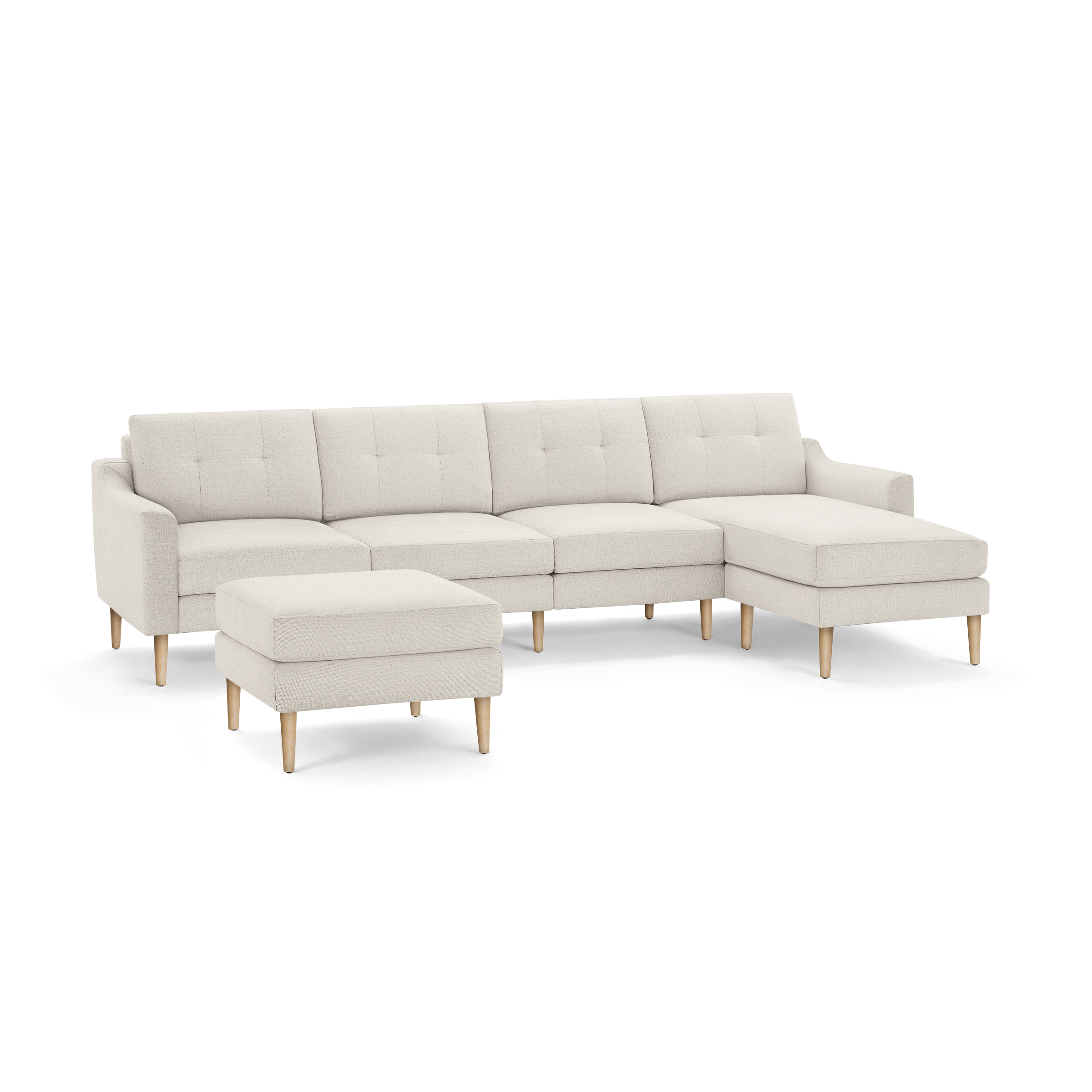 Cream-colored modern sectional sofa with tufted back cushions, wooden legs, and matching ottoman on black background.