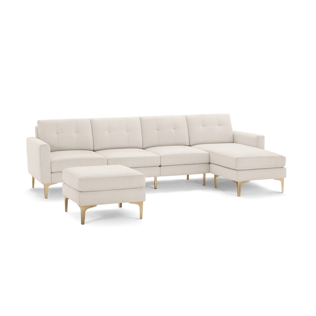 Cream-colored modern sectional sofa with tufted cushions, wooden legs, and matching ottoman on a black background.