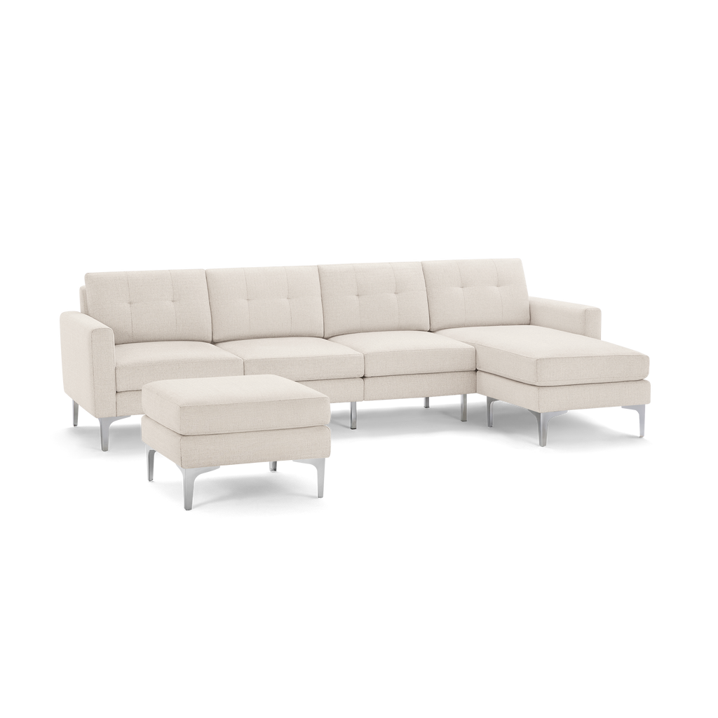 Modern beige sectional sofa with tufted cushions, metal legs, and matching ottoman on a black background.