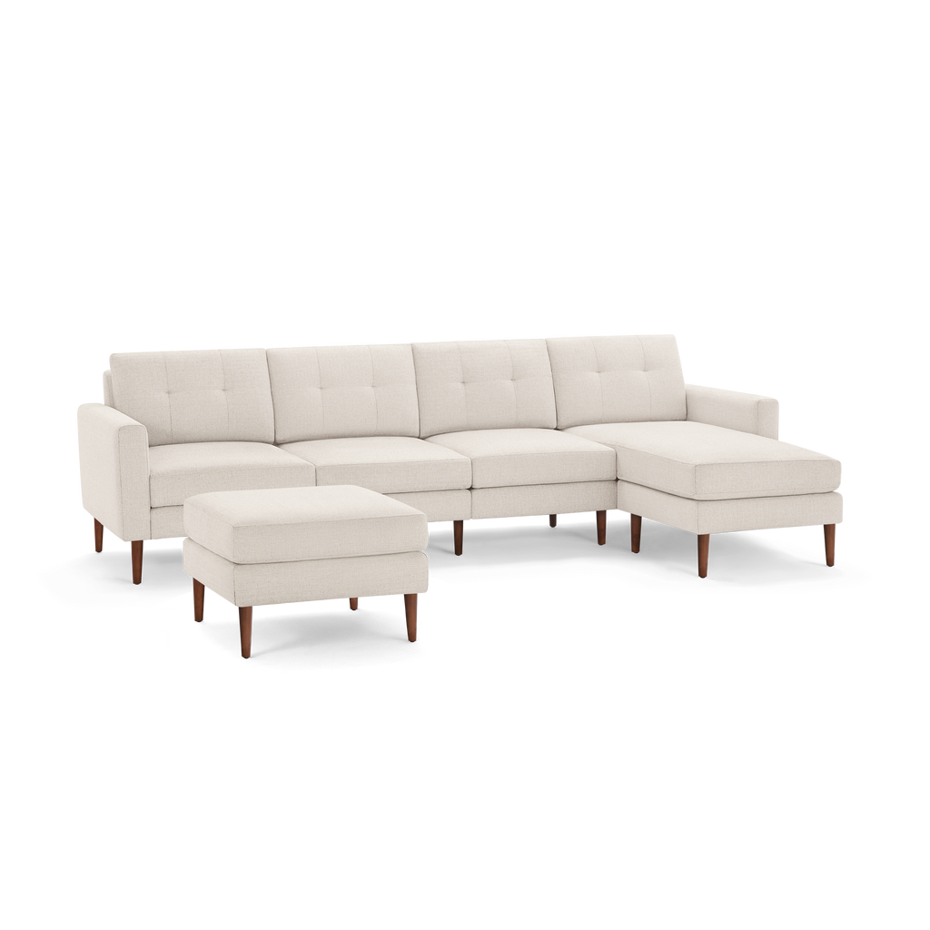 Beige fabric sectional sofa with button-tufted cushions, wooden legs, and a matching ottoman, displayed on white background.