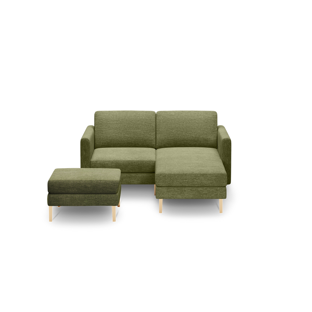 Green fabric chaise lounge sofa with matching ottoman, both featuring light wood legs and modern design.