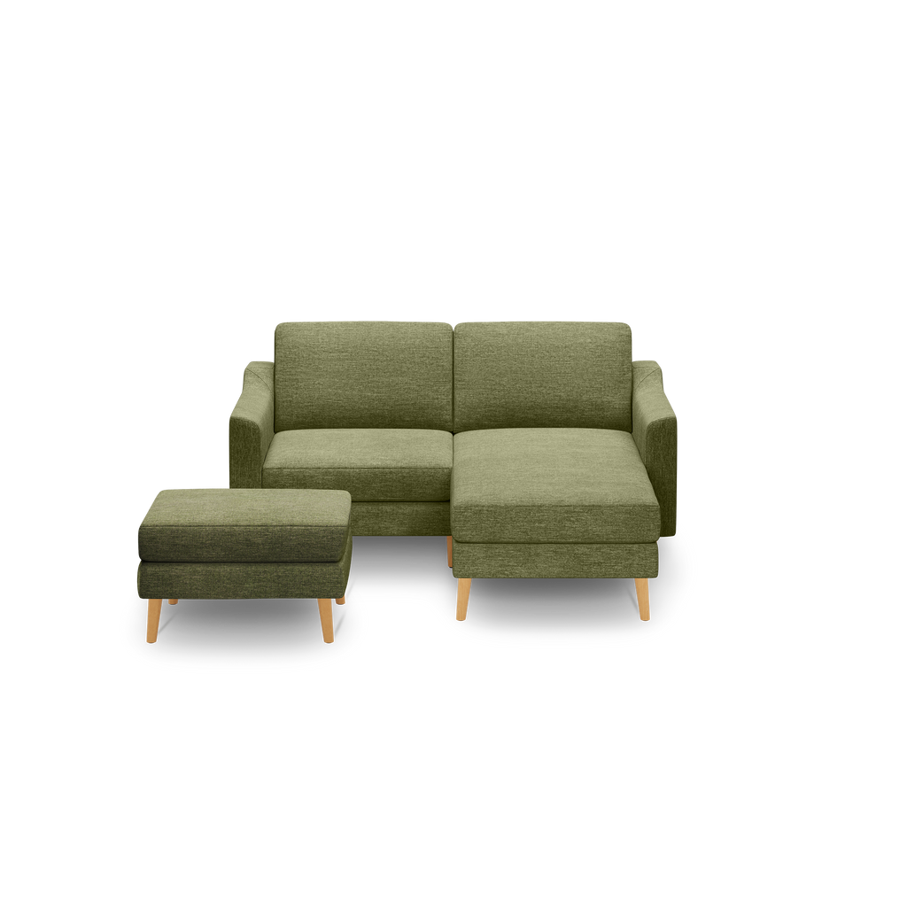 Olive green fabric sectional sofa with wooden legs, featuring a chaise lounge and matching ottoman.