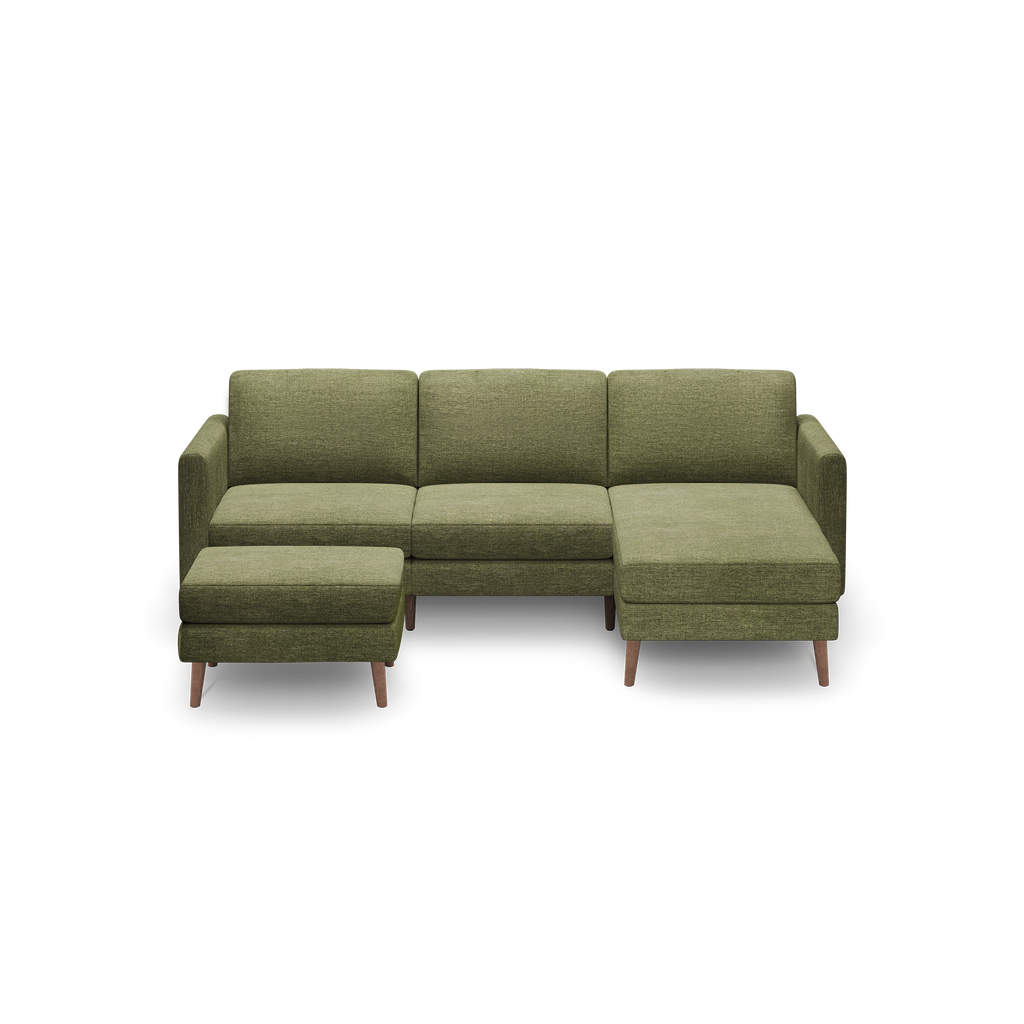 Green upholstered sectional sofa with clean lines, wooden legs, and attached ottoman on left side.
