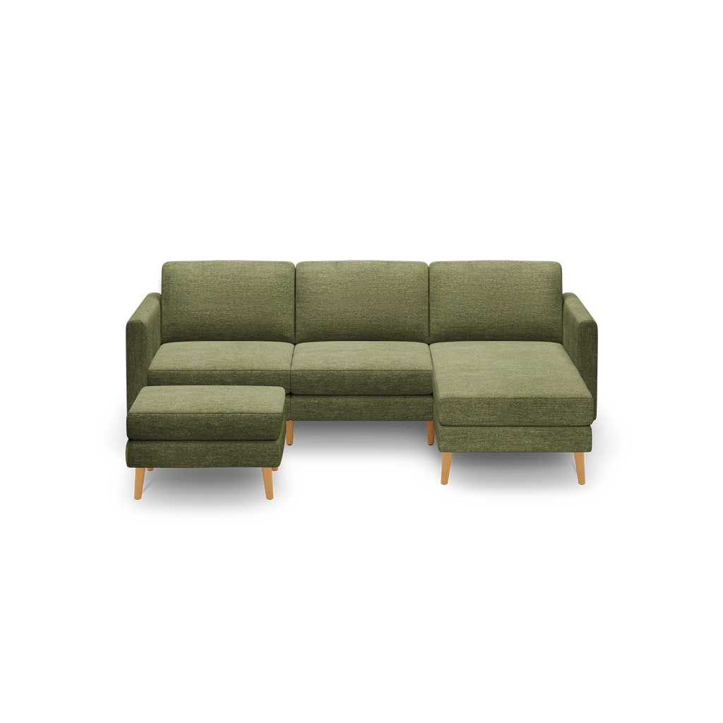 Green fabric sectional sofa with wooden legs, featuring a left-side ottoman and right-side chaise lounge.